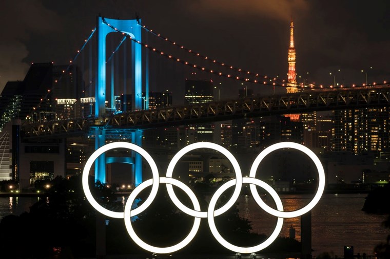 ILLUMINATED OLYMPIC RINGS ARE SEEN IN FRONT OF THE RAINBOW BRIDGE AND THE TOKYO TOWER AT NIGHT