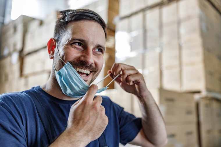 MAN TAKING OF HIS PROTECTIVE FACE MASK