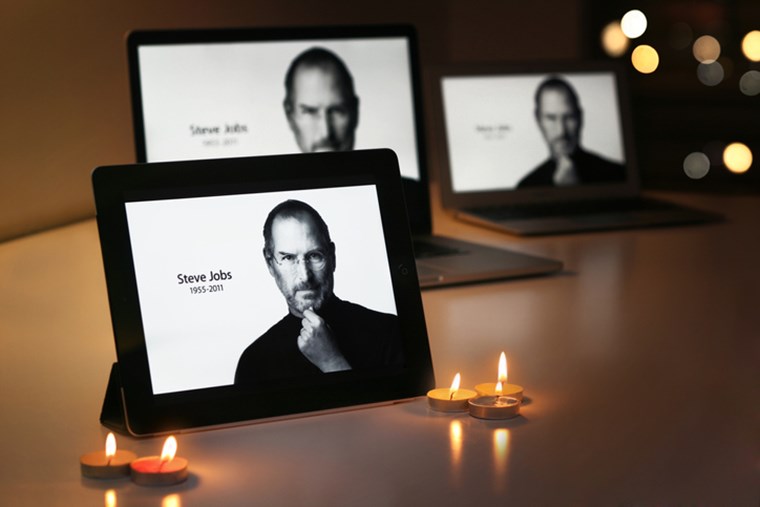 AN IPAD DISPLAYS STEVE JOBS ALONGSIDE CANDLES